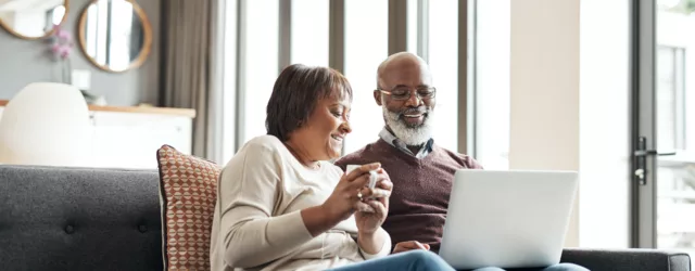 Couple sitting on couch looking at computer